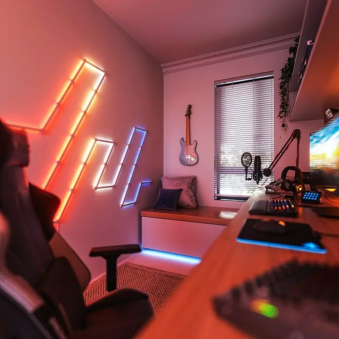 Nanoleaf Erweiterungskit Lines 60 Degrees 3 Lines - 3 Stk., Weiß, RGBW - Gemütliches Spielezimmer mit farbigen Lichtpaneelen an der Wand, das eine entspannende Atmosphäre für lange Spielesitzungen schafft.