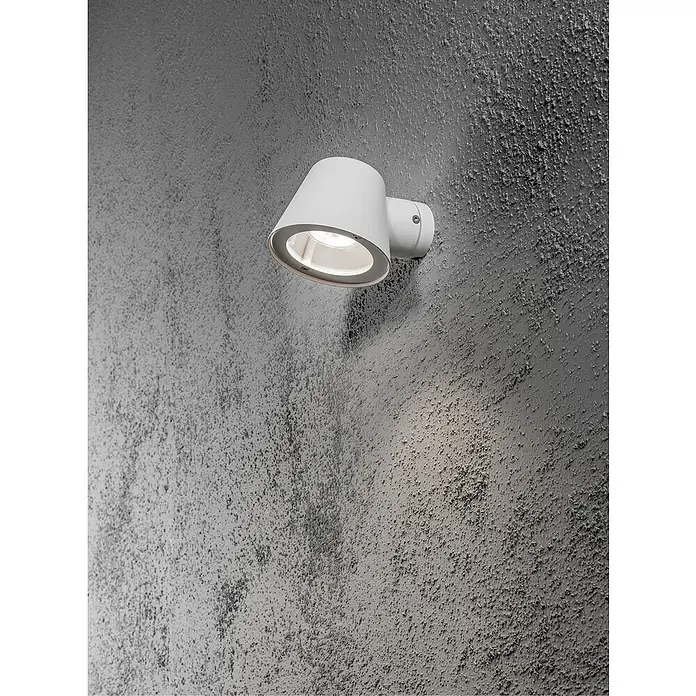 Konstsmide Außenwandleuchte - 35 W, 16 x 11,5 x 11 cm, Weiß, IP44 - Nahaufnahme einer weißen Wandleuchte mit Lichtschein an einer strukturierten grauen Wand.