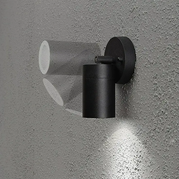 Konstsmide Außenwandleuchte - 25 W, 10,5 x 20 x 10 cm, Schwarz, IP44 - Eine moderne, schwarze Wandleuchte mit zylindrischem Design, die ein warmes Licht nach unten wirft und eine interessante Schattenwirkung erzeugt.