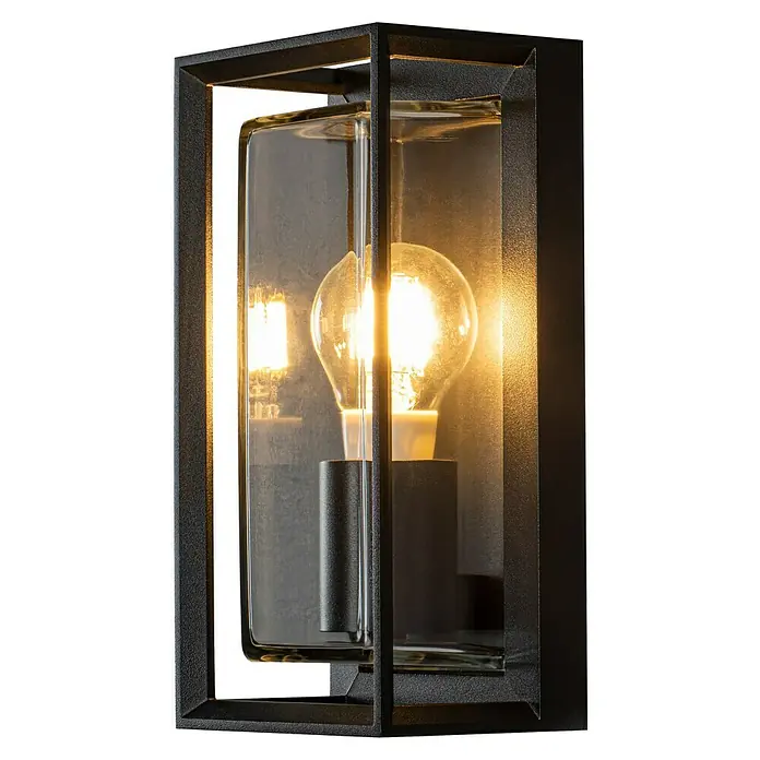 Konstsmide Außenwandleuchte - 20 W, 29 x 16 x 38 cm, Schwarz, IP54 - Nahaufnahme einer modernen Außenwandleuchte mit schwarzem Rahmen und klarem Glas, die ein warmes Glühbirnenlicht zeigt.