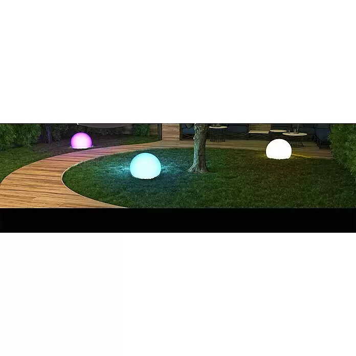 Müller-Licht Tint LED-Kugel Calluna - E27, 9,6 W, 806 lm - Drei leuchtende kugelförmige Gartenleuchten in Lila, Blau und Weiß erhellen einen Rasenbereich mit Holzweg.