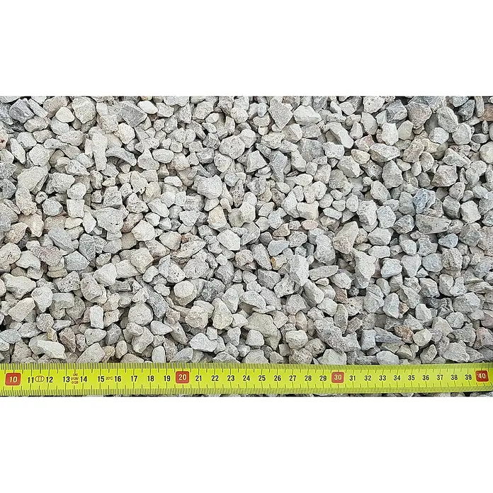 BHS Mallorca Big Bag de grava 2 - Gris - Primer plano de pequeñas piedras de grava grises con una cinta métrica amarilla que indica el tamaño de las piedras.