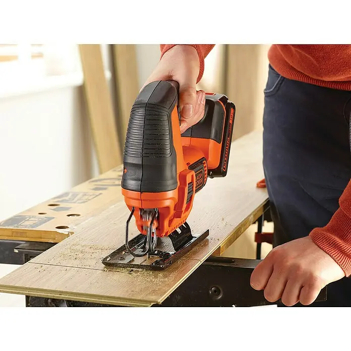 Black+Decker Pendelhubstichsäge BDCJS18-QW18 V, 1 Akku, 2 Ah, 0 /min - 2.500 /min - Eine Black+Decker Akku-Stichsäge schneidet präzise ein Holzbrett. Das Werkzeug ist orange-schwarz und wird von Hand geführt.
