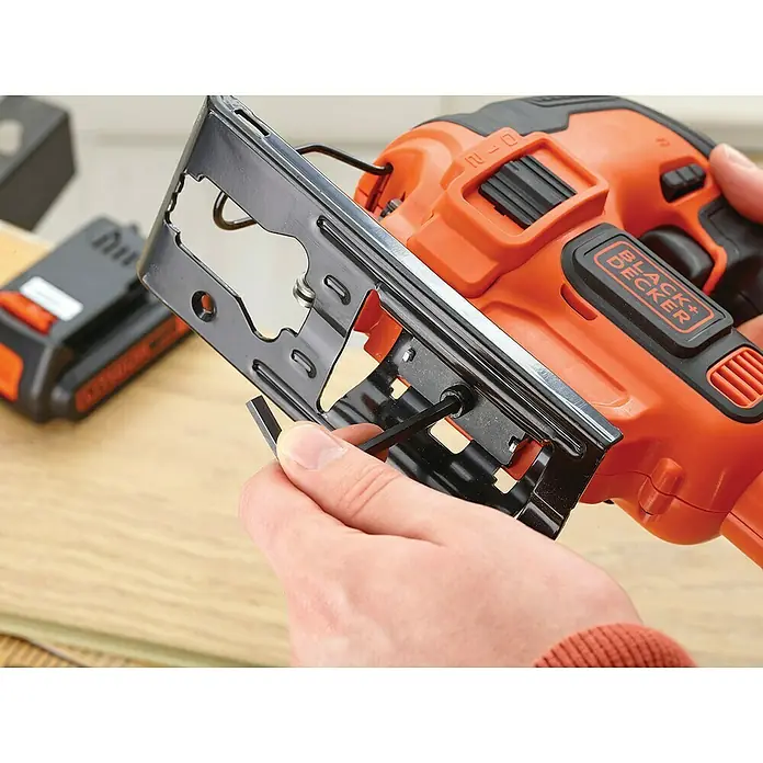 Black+Decker Pendelhubstichsäge BDCJS18-QW18 V, 1 Akku, 2 Ah, 0 /min - 2.500 /min - Nahaufnahme einer BLACK+DECKER Stichsäge, die mit einem Inbusschlüssel eingestellt wird, wobei der Fokus auf dem Werkzeug und dem Einstellvorgang liegt.