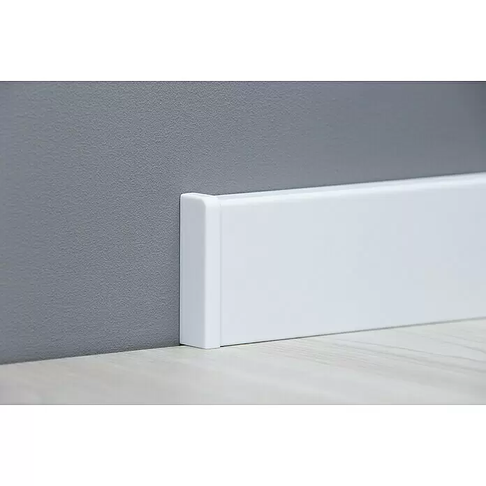 Endkappe Modern 58 - Weiß, 2 Stk. - Weißer Sockelleiste mit Endkappe an grauer Wand und hellem Holzfußboden.