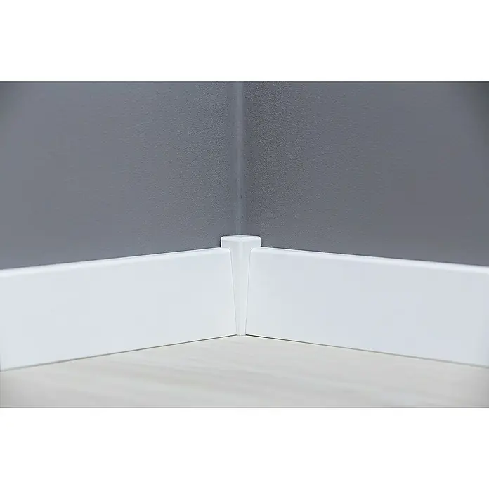 Sockelleiste - 240 cm x 18 mm x 58 mm, MDF, Weiß - Weiße Sockelleisten treffen auf einem grauen Hintergrund aufeinander und bilden eine Ecke. Der Raum wirkt hell und modern.
