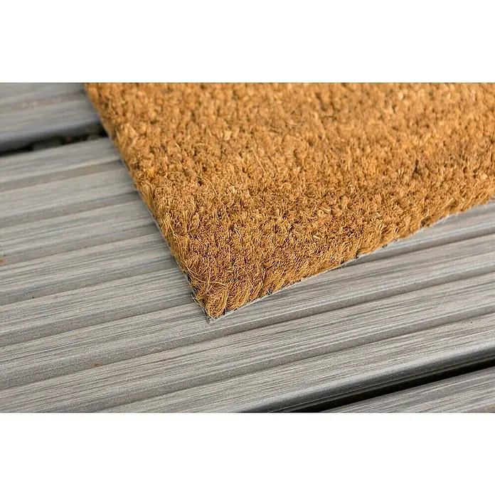 Astra Fußmatte - 40 x 60 cm, Natur, Material Nutzschicht: 100 % Kokos, Höhe: 15 mm - Detailansicht einer fußabtreter aus Kokosfasern auf einer grauen Holzterrasse, die Textur und Robustheit hervorhebt.
