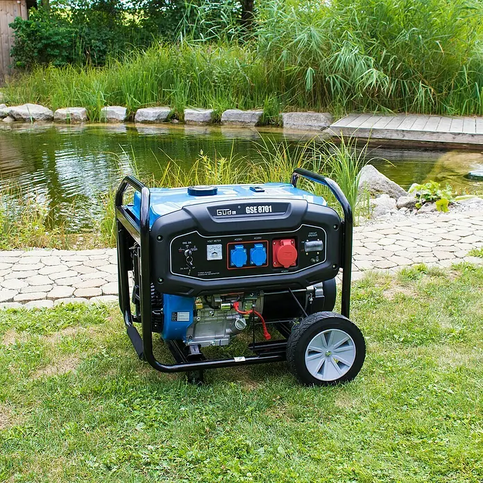 Güde Stromerzeuger GSE 8701 RS - 3,5 kW - 7,8 kW, Tankvolumen: 25 l, Verbrauch: 4,2 l/h - Ein Güde GSE 8701 Stromerzeuger steht auf einer grünen Wiese und bietet zuverlässige Stromversorgung im Freien. Kompakt und robust für vielfältige Anwendungen.