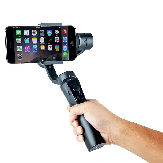Voltomat Smartphone-Halter 3-Achsen-Gimbal - Schwarz, Höhe: 29,1 cm - Ein Smartphone, das in einem Gimbal-Stabilisator befestigt ist, wird von einer Hand gehalten.