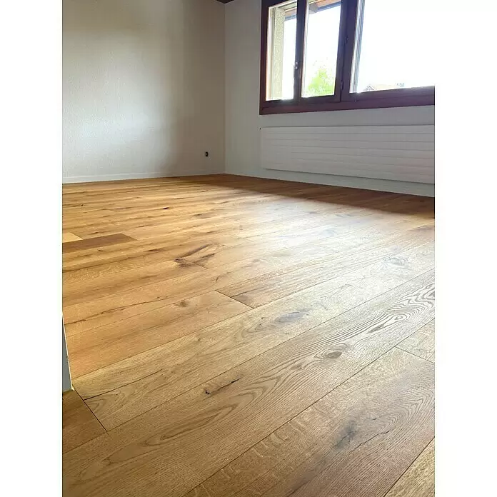 Parkett - Eiche Laura, Landhausdiele, 2.200 x 240 x 15 mm - Neue helle Holzdielen mit Naturmaserung und Ästen in einem leeren Raum.