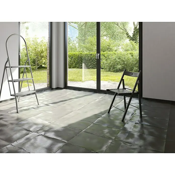 Probau Baufolie - 10 m x 3 m x 0,2 mm, Polyethylen, Transluzent - Das Bild zeigt eine silberne Leiter und einen dunklen Holzstuhl in einem Raum mit Fenster und abgedecktem Boden.