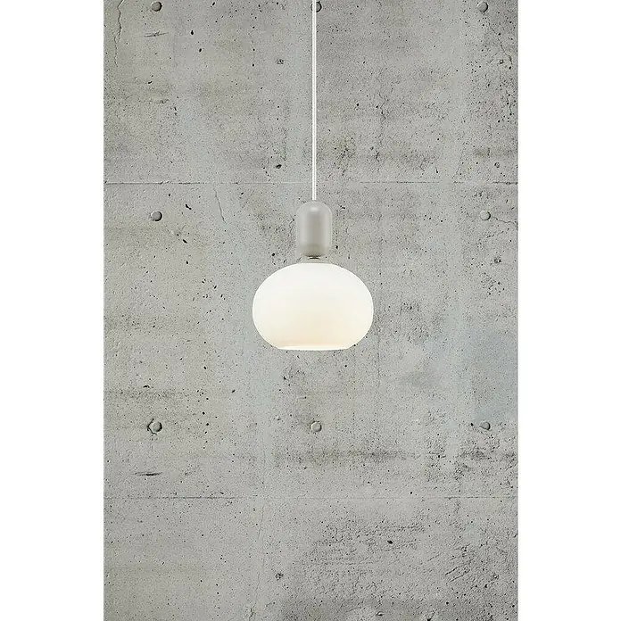 Nordlux Notti Lámpara colgante redonda - 40 W, Ø x Al: 20 x 23,8 cm, Gris, E27 - Primer plano de una lámpara colgante moderna con una pantalla redonda de vidrio blanco y una fijación gris contra una pared de hormigón.