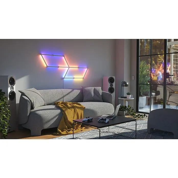 Nanoleaf Erweiterungskit Lines 60 Degrees 3 Lines - 3 Stk., Weiß, RGBW - Wohnzimmer mit farbigen Nanoleaf Lines Lichtleisten an der Wand, die eine gemütliche Atmosphäre schaffen.