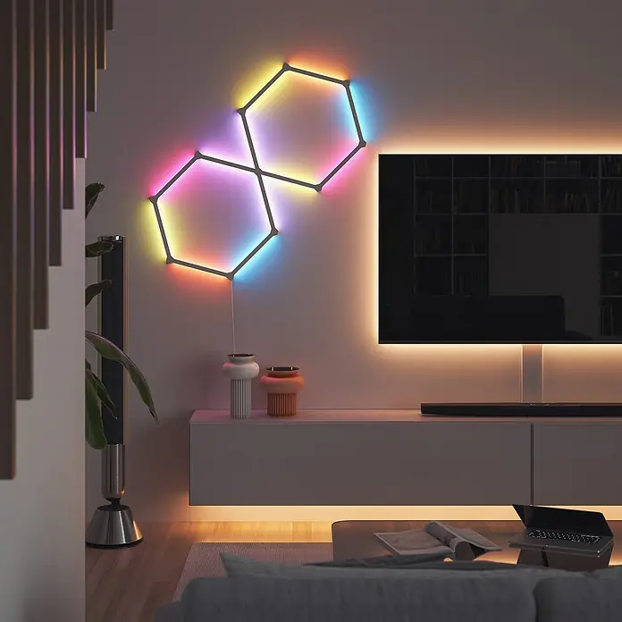 Nanoleaf Erweiterungskit Lines 60 Degrees 3 Lines - 3 Stk., Weiß, RGBW - Das Bild zeigt eine Nanoleaf Shapes Wandleuchte in einem Wohnzimmer, die ein farbenfrohes und modernes Ambiente schafft.
