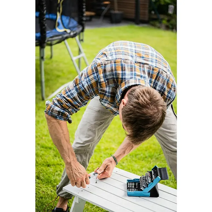 Hazet Steckschlüssel-Set SmartCase - 50 Stk. - Ein Mann arbeitet im Freien mit einem Gardena Werkzeugkasten, um ein Möbelstück zu montieren.