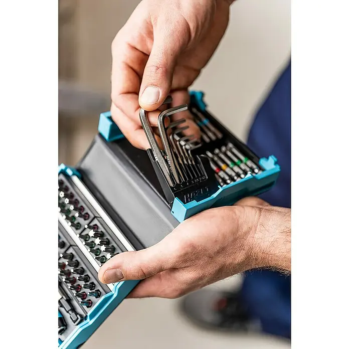 Hazet Bit-Set SmartCase - 69 Stk. - Ein Werkzeugkoffer mit diversen Schraubendreher-Bits und Inbusschlüsseln wird von einer Hand geöffnet.