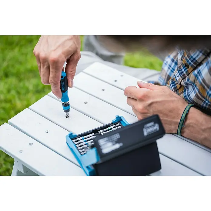 Hazet Bit-Set SmartCase - 69 Stk. - Ein HAZET Schraubendreher-Set wird auf einem weißen Holztisch verwendet, perfekt für präzise Reparaturen und DIY-Projekte.