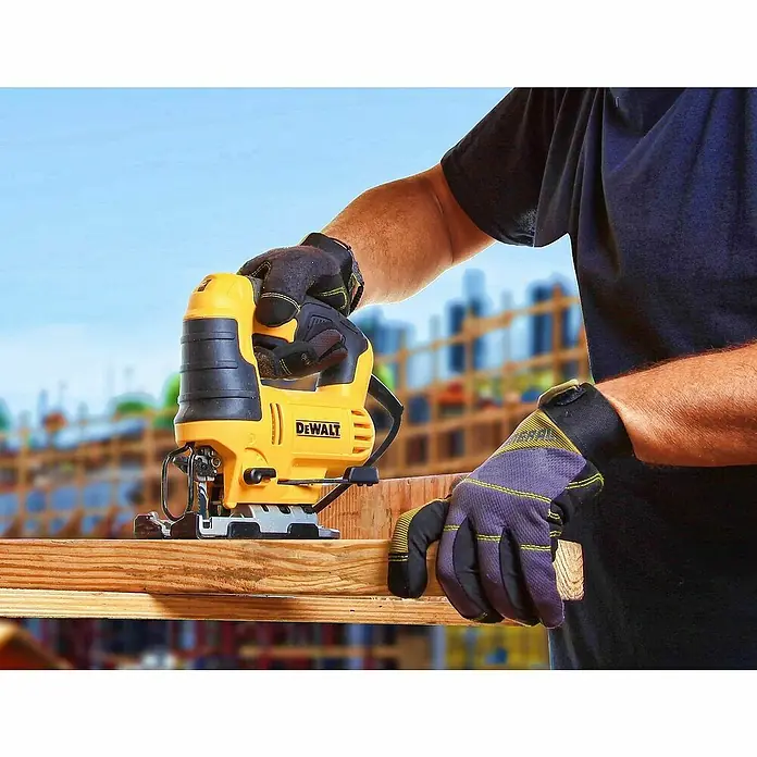 DeWalt Elektro-Pendelhubstichsäge DWE349-QS - 500 /min - 3.200 /min, Max. Schnitttiefe in Holz: 85 mm, Anzahl Pendelhubstufen: 3 Stk. - Nahaufnahme einer gelben DEWALT Stichsäge im Einsatz, die ein Holzbrett durchschneidet, bedient von einer Person mit Arbeitshandschuhen.