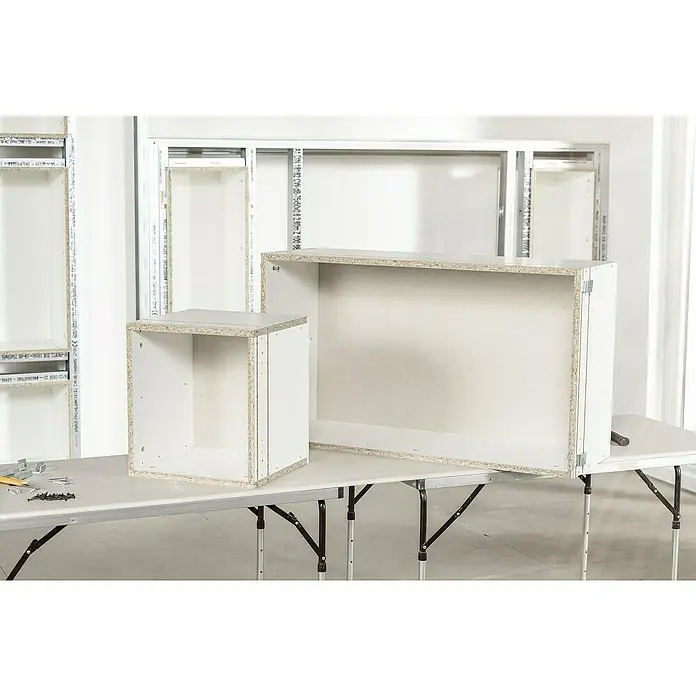 Knauf Wandnischen-Set M - 60 x 36,2 cm - Nahaufnahme von zwei unfertigen weißen Schränken auf einem Tisch, die die Konstruktionsdetails hervorheben.