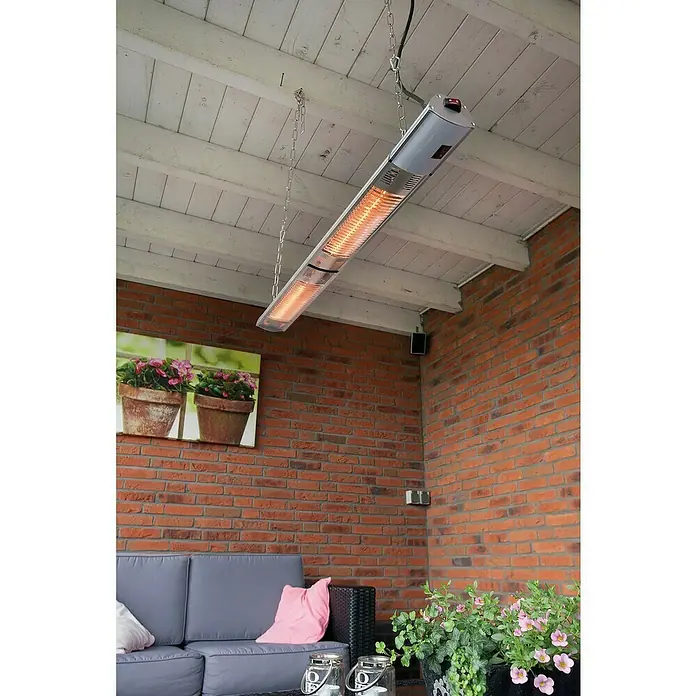Sunred Halogen-Heizstrahler Royal Diamond - L x B: 102 x 12 cm, 3.000 W, Silbergrau - Diese Aufnahme zeigt einen Deckenstrahler, der mit Ketten an einer Holzdecke befestigt ist und eine gemütliche Atmosphäre erzeugt.