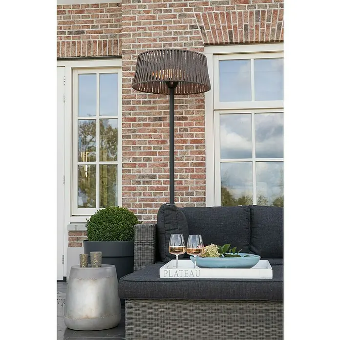 Sunred Halogen-Heizstrahler CordaHöhe: 213 cm, 2.100 W, Braun - Ein stilvolles Außenambiente mit einem Terrassenheizer, der für Wärme und Atmosphäre sorgt, ergänzt durch eine elegante Loungegruppe und Dekoration.