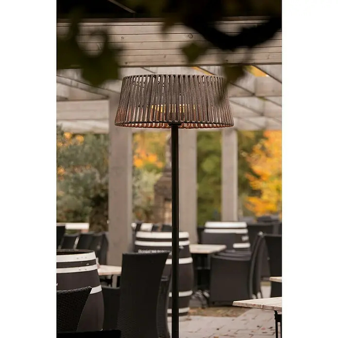 Sunred Halogen-Heizstrahler CordaHöhe: 213 cm, 2.100 W, Braun - Eine elegante Außenleuchte mit einem geflochtenen Lampenschirm, die eine warme Atmosphäre auf einer Terrasse oder in einem Garten schafft.