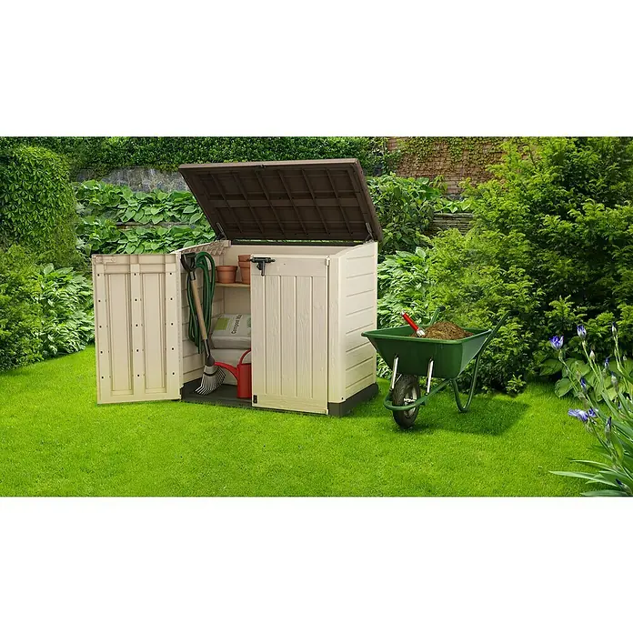 Keter Arcón Store it out Max - L x An x Al: 82 x 145,5 x 125 cm, Marrón - Caseta de almacenamiento exterior con tapa abierta y una carretilla llena de tierra. Solución práctica para herramientas de jardín.