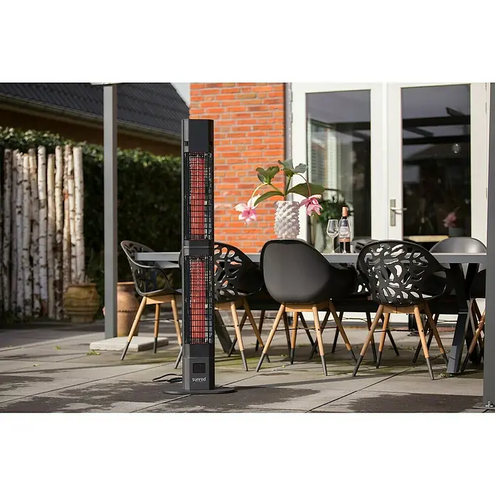 Sunred Infrarot-Heizstrahler Royal Diamond Valencia - 3.000 W, Schwarz, Höhe: 150 cm - Das Bild zeigt einen Sunred-Terrassenheizer, der auf einer Terrasse neben einem Esstisch und Stühlen steht. Er sorgt für Wärme und Komfort im Freien.