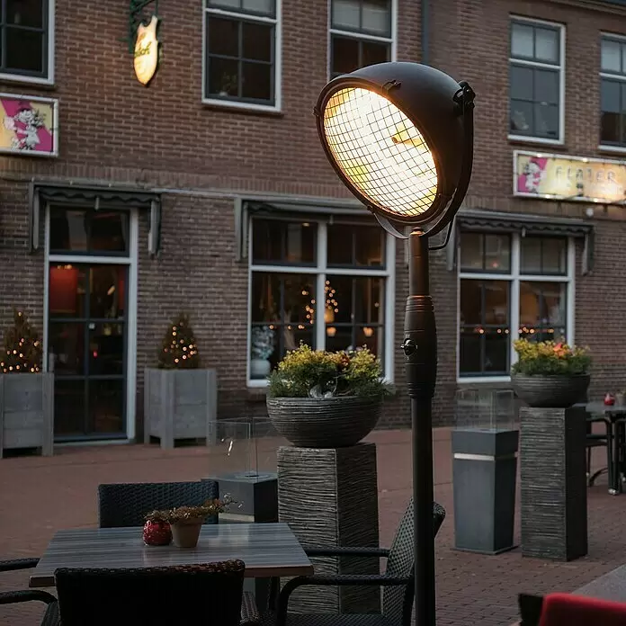 Sunred Halogen-Heizstrahler Indus - Höhe: 210 cm, 2.100 W, Schwarz - Schwarzer Terrassenheizer im Industriestil, der einen Café-Sitzbereich im Freien beleuchtet.