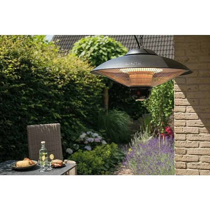 Sunred Halogen-Heizstrahler Sirius - Durchmesser: 58,5 cm, 2.100 W, Schwarz - Bild einer schwarzen, hängenden Terrassenheizung über einem Tisch mit Speisen im Freien.