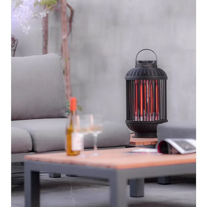 Sunred Heizstrahler Indox - Höhe: 59 cm, 1.200 W, Schwarz - Eine Sunred Infrarot-Terrassenheizung in einem modernen Außenbereich. Die Heizung strahlt warmes, rotes Licht aus.