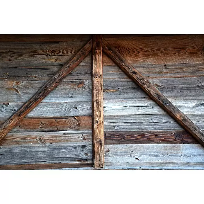 Dekobalken Altholz - Fichte/Tanne, L x S: 250 x 5 cm, Anfallende Breite: 10 cm - 16 cm - Verwitterte Holzwand aus braunen und grauen Dielen, verstärkt durch dunkelbraune diagonale und vertikale Balken in A-Form.