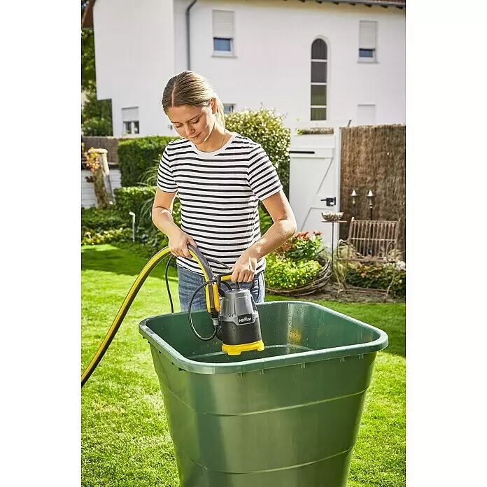 Neptun Klarwasser-Tauchpumpe NKP-E 22 - 220 W, Max. Fördermenge: 7.500 l/h - Person senkt eine schwarz-gelbe Tauchpumpe mit angeschlossenem Schlauch in einen grünen Wasserbehälter für den Gartengebrauch.