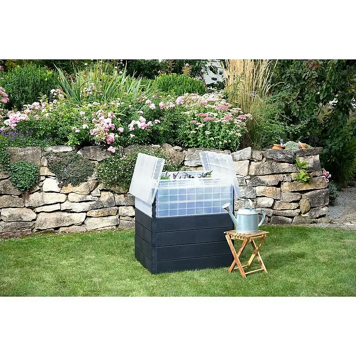 Garantia Hochbeet Ergo Quadro Turbo Plus M Stone - Set - 80 x 60 x 85 cm, Kunststoff, Anthrazit - Ein Mini-Frühbeet auf einem erhöhten Beetkasten mit einer Gießkanne auf einem Holzhocker im Garten.