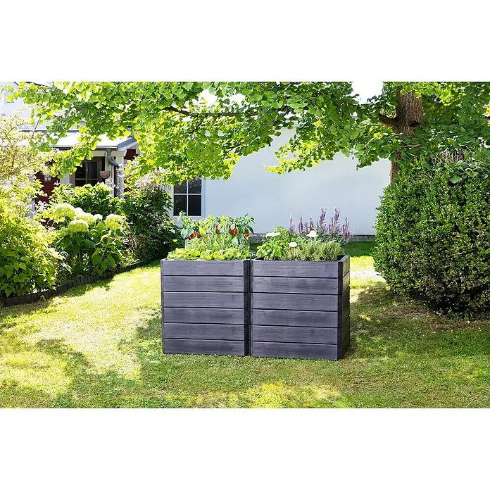 Garantia Hochbeet Ergo Vario 2 Wood - Set - 120 x 80 x 75 cm, Kunststoff, Anthrazit/Braun - Zwei graue Hochbeete aus Holz mit Gemüse und Kräutern bepflanzt stehen im Garten unter einem Baum und bieten Platz für den Anbau eigener Pflanzen.