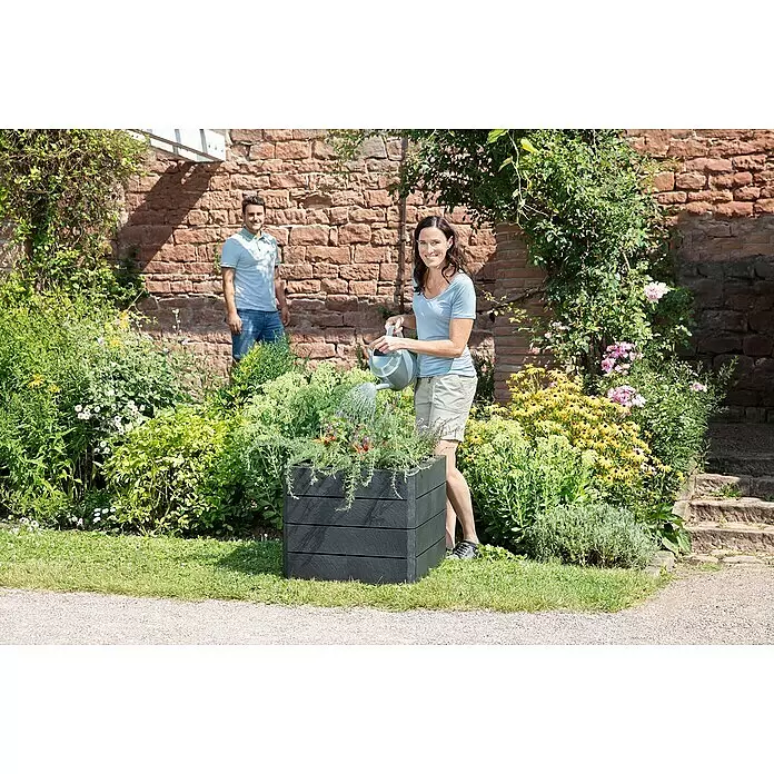 Garantia Hochbeet Ergo Quadro S Stone - Set - 60 x 60 x 50 cm, Kunststoff, Anthrazit - Schwarzes Hochbeet mit Pflanzen, das gerade bewässert wird.