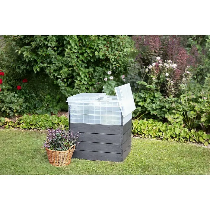 Garantia Hochbeet Ergo Quadro Turbo Plus M Wood - Set - 60 x 80 x 85 cm, Kunststoff, Anthrazit/Braun - Ein geräumiger Kompostbehälter aus Kunststoff und Holzimitat steht im Garten, daneben ein Korb mit lila Blumen.