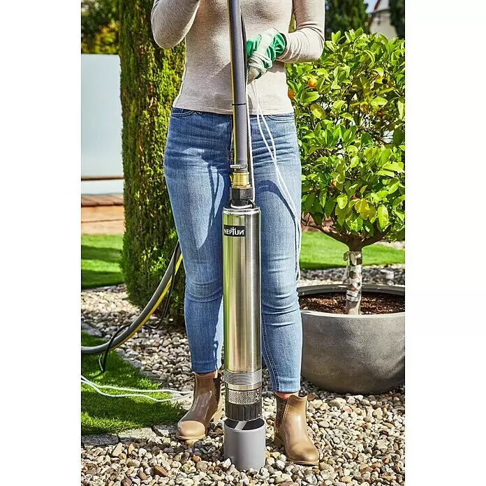 Neptun Tiefbrunnenpumpe NTP-E 100 - 1.000 W, Max. Fördermenge: 6.500 l/h - Edelstahl-Tauchpumpe von Neptun, von einer Person im Garten gehalten, einsatzbereit.