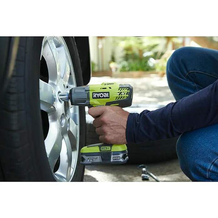 Ryobi ONE+ Akku-Schlagschrauber R18IW3-0 - 18 V, Ohne Akku, 400 Nm - Ein Mann benutzt einen Ryobi Akku-Schlagschrauber, um die Radmuttern an einem Auto zu lösen. Ryobi Werkzeug mit grüner Akku.