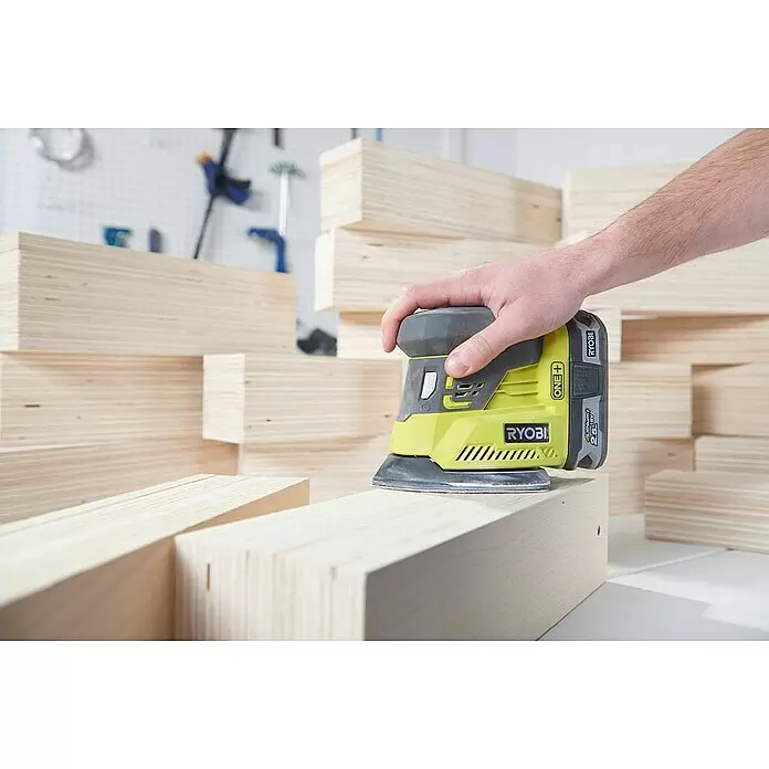 Ryobi ONE+ Maschinen-Set Combo Kit R18CK4E-242S - 18 V, 2 Akkus, 8 -tlg. - Eine Hand bedient einen gelb-grauen Akku-Exzenterschleifer, der ein helles Holzbrett zwischen gestapelten Holzbrettern schleift.