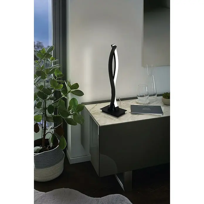 Eglo Lasana 3 Lámpara de sobremesa LED - 10 W, L x An x Al: 10 x 16 x 46 cm, Negro, Blanco cálido - Primer plano de una lámpara de mesa LED moderna en blanco y negro sobre una mesita de noche con encimera de mármol, que emite una luz brillante y acogedora.