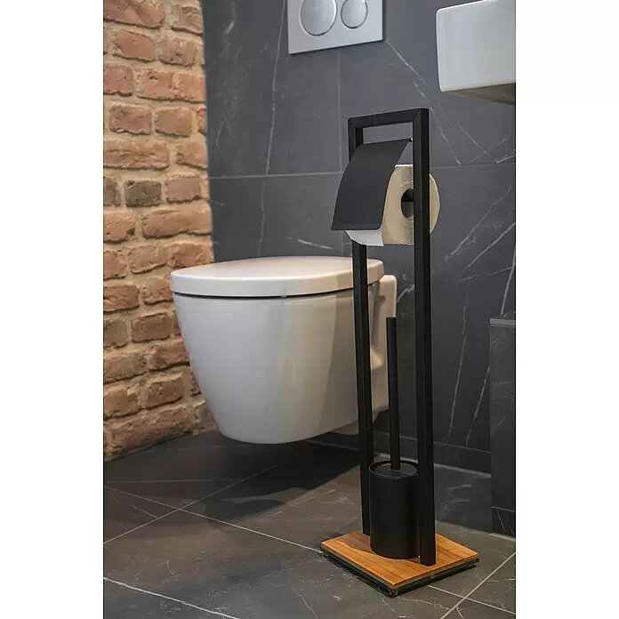 Wenko Bambusa WC-Kombi-Bürstengarnitur - Höhe: 72,5 cm, Schwarz/Bambus, Matt - Schwarzer freistehender Toilettenpapierhalter und Bürste mit Holzsockel, in einem modernen Bad neben einer weißen Toilette.