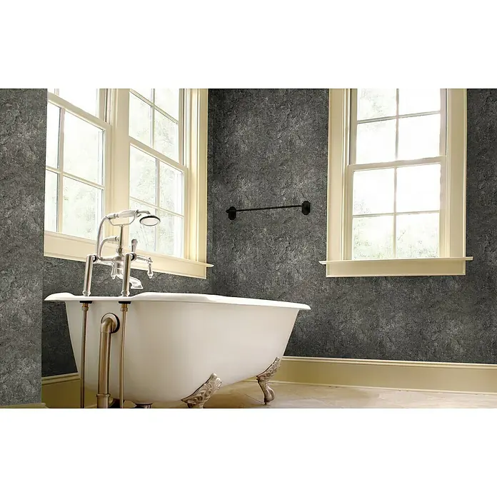 Papel pintado de vinilo autoadhesivo PF-076-2 - 90 cm x 3,3 m, 100% PVC - Primer plano de una bañera exenta con accesorios y patas plateadas en un elegante baño con papel pintado de textura de piedra gris.