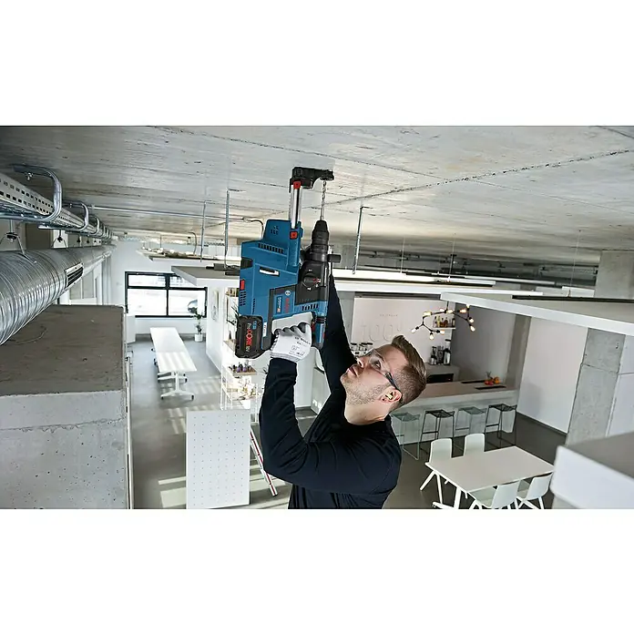 Bosch Professional AMPShare 18V Akku-Kombihammer GBH 18V-26 F - 18 V, 2 Akkus, 5,5 Ah, 2,6 J, Inkl. Staubabsaugung - Ein Handwerker bohrt mit einem Bosch Bohrhammer eine Decke. Der Akku-Bohrhammer ist blau und hat einen schwarzen Griff.
