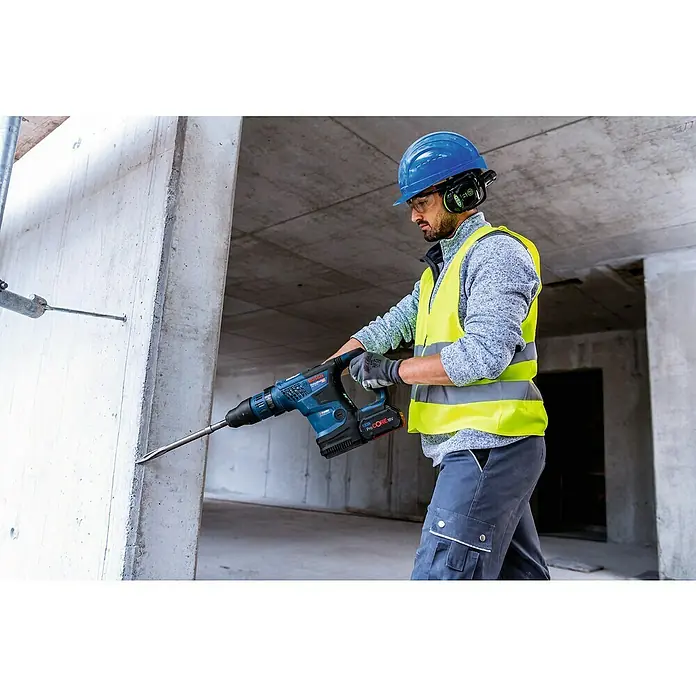 Bosch Professional AMPShare 18V Akku-Kombihammer GBH 18V-36 C - 18 V, 2 Akkus, 8 Ah, 7 J - Ein Bauarbeiter benutzt einen Bosch Akku-Bohrhammer zum Aufbrechen von Beton. Der Bohrhammer ist blau und hat einen schwarzen Akku.