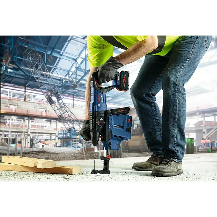 Bosch Professional AMPShare 18V Akku-Kombihammer GBH 18 V-26 D - 18 V, Ohne Akku, 2,5 J - Ein Bauarbeiter benutzt einen Boschhammer Professional zum Bohren mit einem Akku ProCore 18V, während er auf einer Baustelle arbeitet.