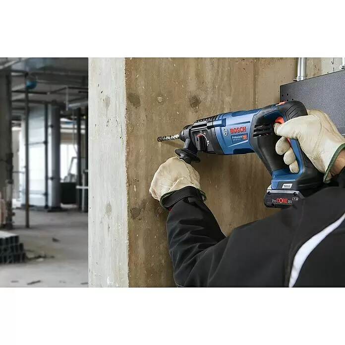 Bosch Professional AMPShare 18V Akku-Kombihammer GBH 18 V-26 D - 18 V, Ohne Akku, 2,5 J - Eine Person bohrt mit einem blau-schwarzen Bosch Bohrhammer, betrieben mit einem ProCORE 18V 4.0 Ah Akku, in eine Betonwand.