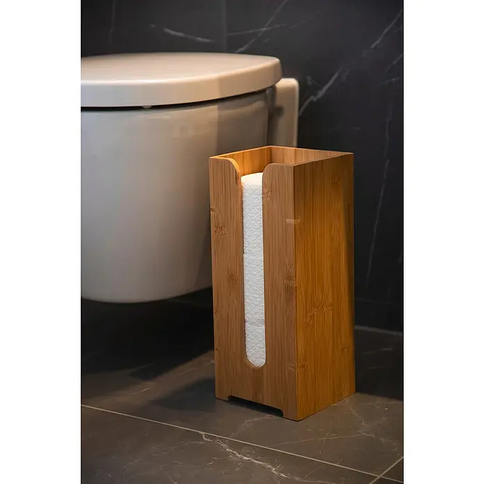 Wenko Bambusa Ersatzpapierrollenhalter - Bambus - Badezimmer-Szene mit Toilettenpapierhalter aus Bambus neben einer Toilette auf einem grauen gefliesten Boden.