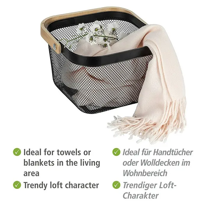 Wenko Bambusa Bad-Aufbewahrungskorb25 x 25 x 17 cm, Stahl, Schwarz/Bambus - Bild eines schwarzen Drahtkorbs mit hellem Holzgriff, gefüllt mit einer cremefarbenen Decke und weißen Blumen.