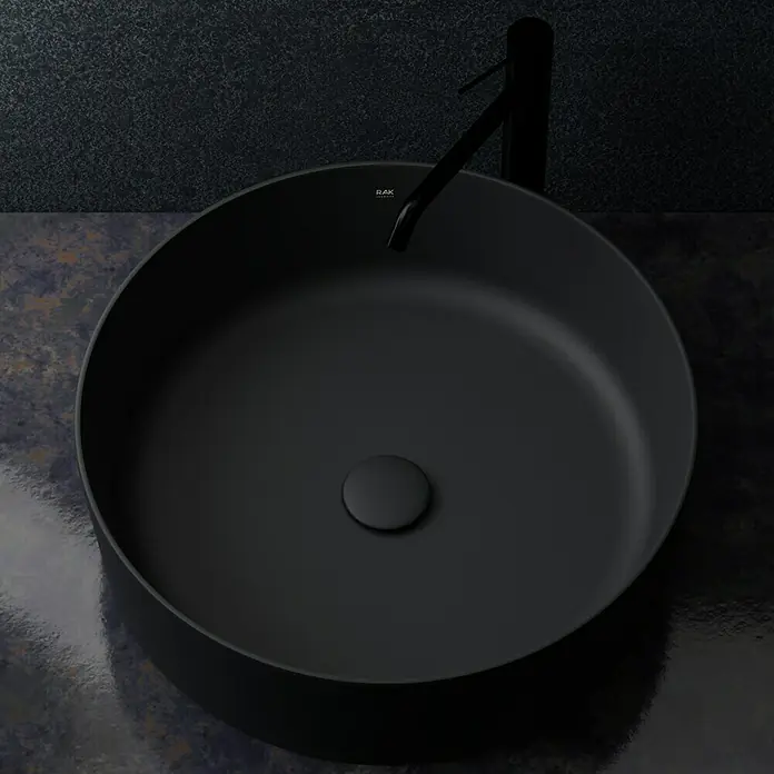 RAK Ceramics Feeling Ablaufventil - 1 ¼″, Schwarz, Permanent geöffnet - Schwarzes, rundes Waschbecken mit Wasserhahn, das ein elegantes und modernes Badezimmerdesign ausstrahlt.